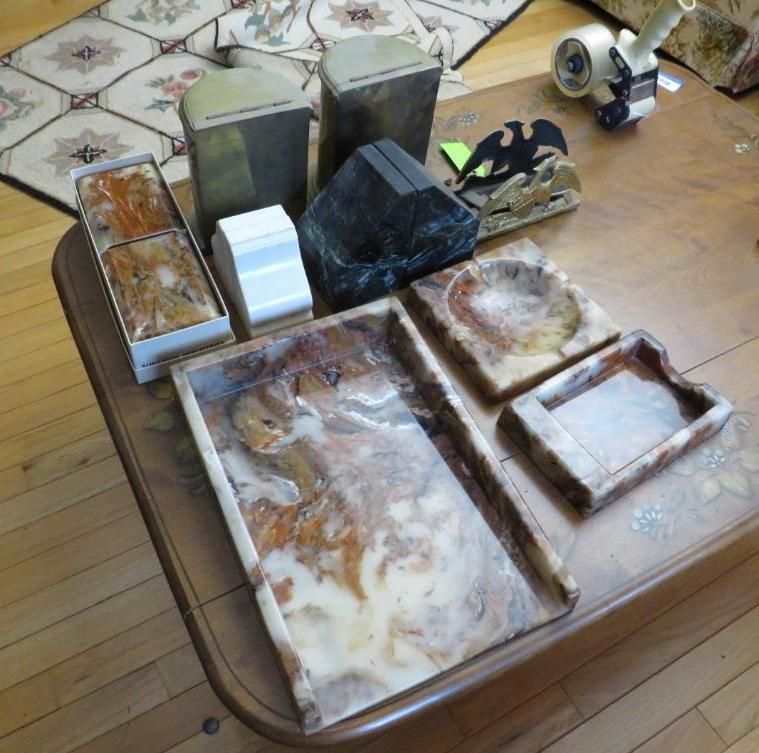 Various stone objects, including trays, ashtrays, and boxes, on a wooden table.