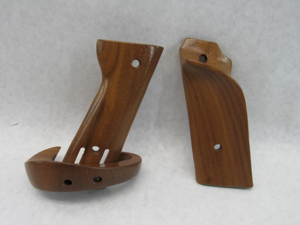 Two brown wooden gun grips on a white surface, one with a full grip, the other a side panel.
