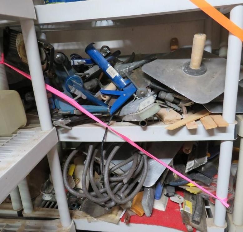 Shelves with tools: caulking gun, trowels, and coiled cables.