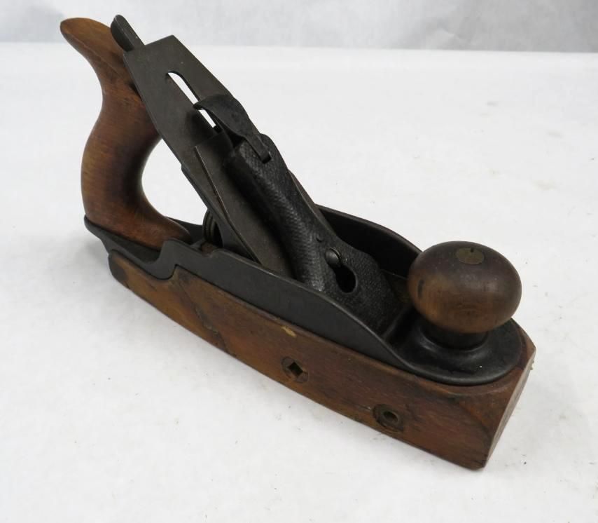 Wooden hand plane tool with a dark metal blade.