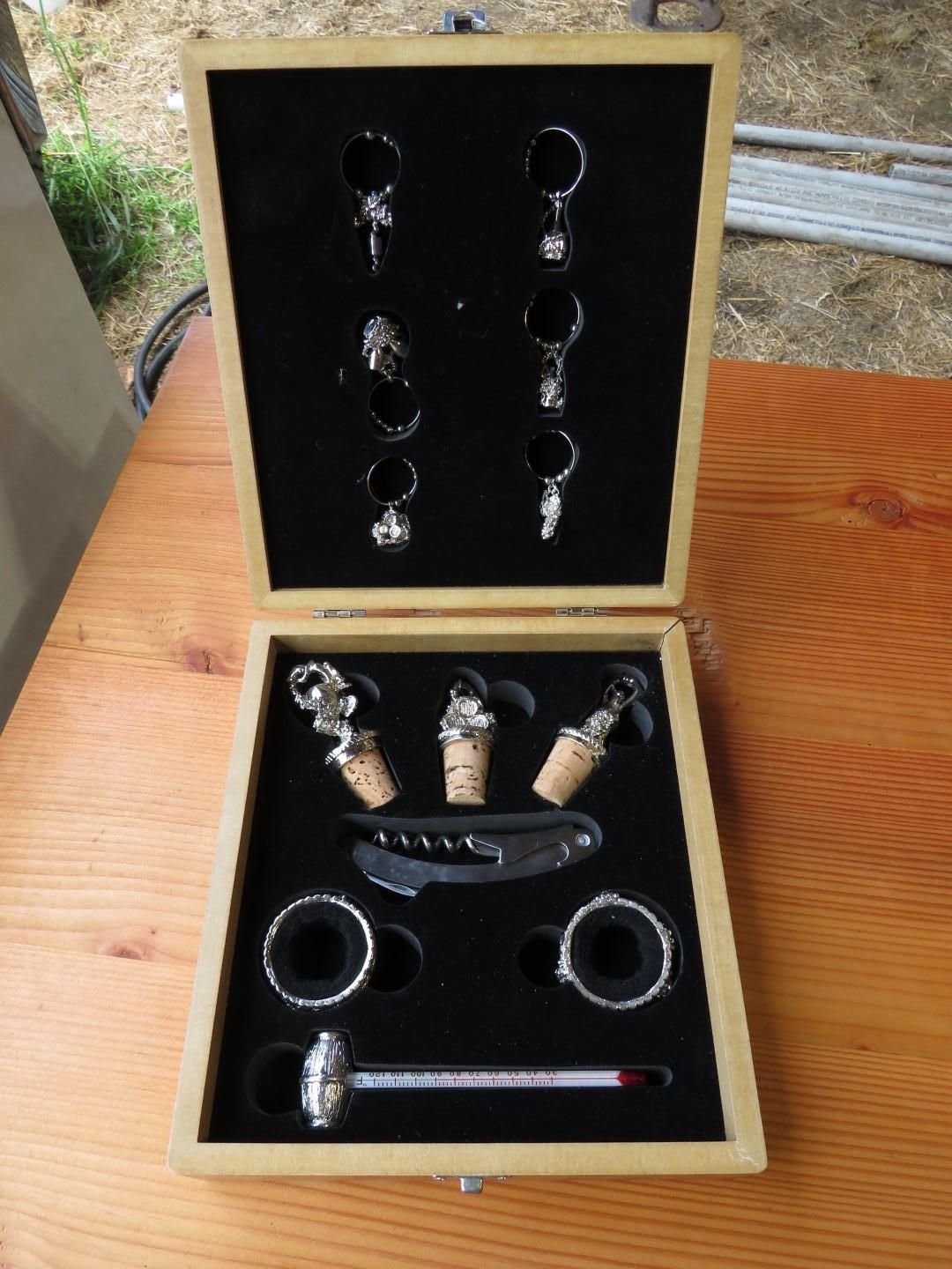 Wooden wine accessory set with various tools, including bottle stoppers, corkscrew, and thermometer.