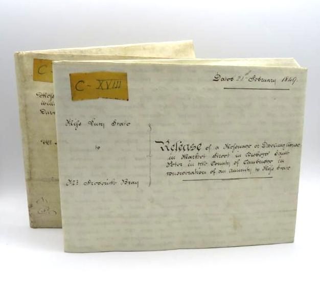 Two antique, bound books with handwritten titles and labels on cream-colored paper.