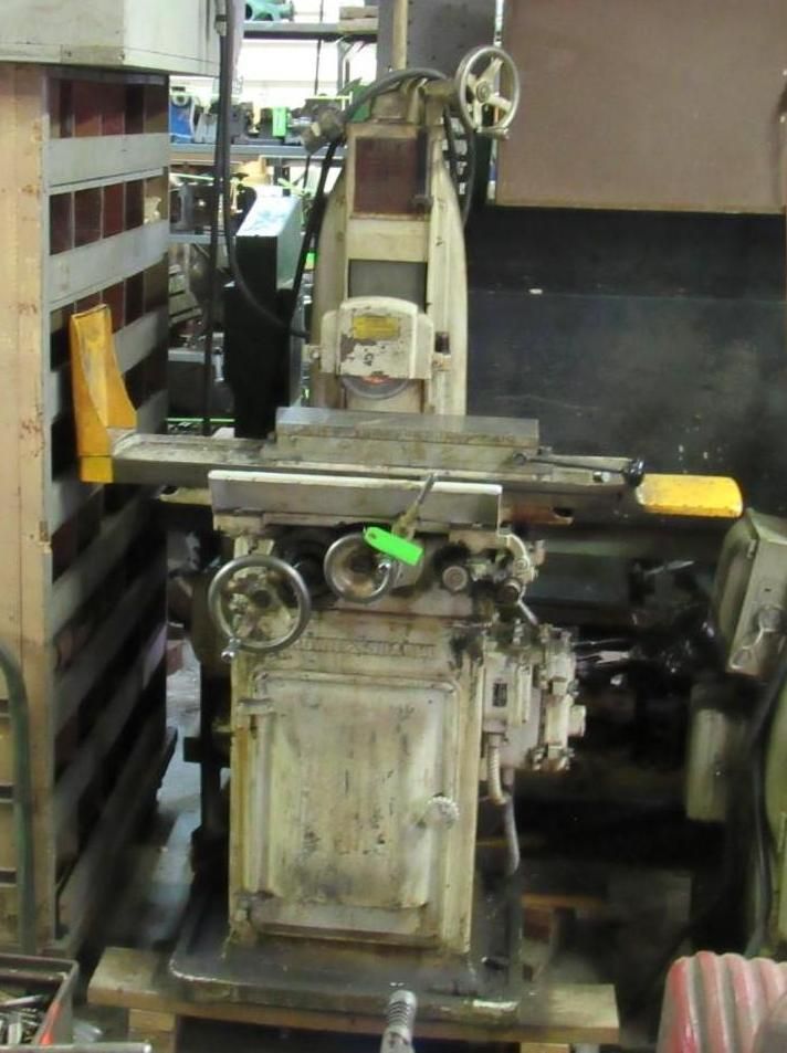 A beige industrial surface grinder machine in a workshop setting.