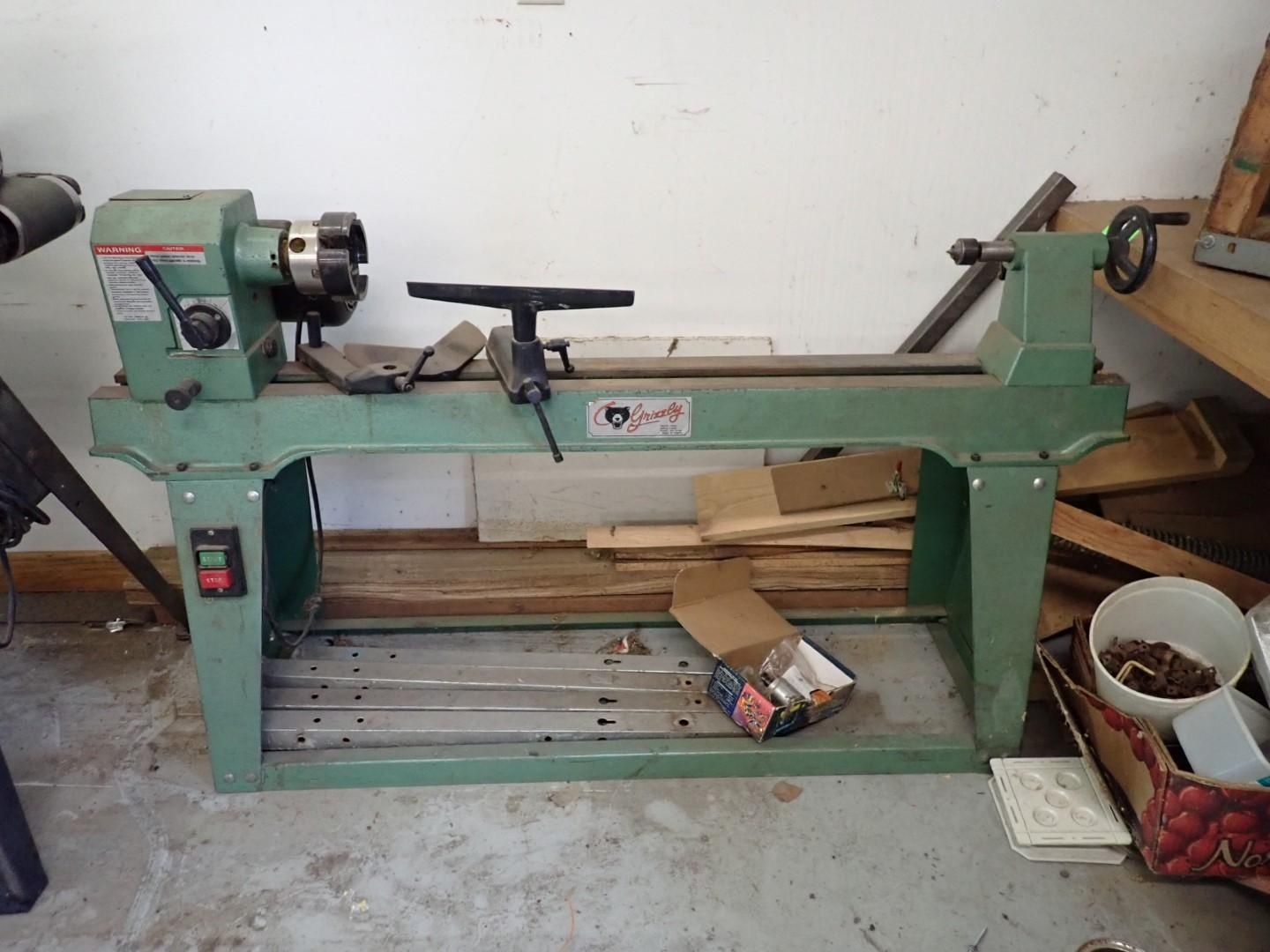 Green wood lathe machine in a workshop setting.