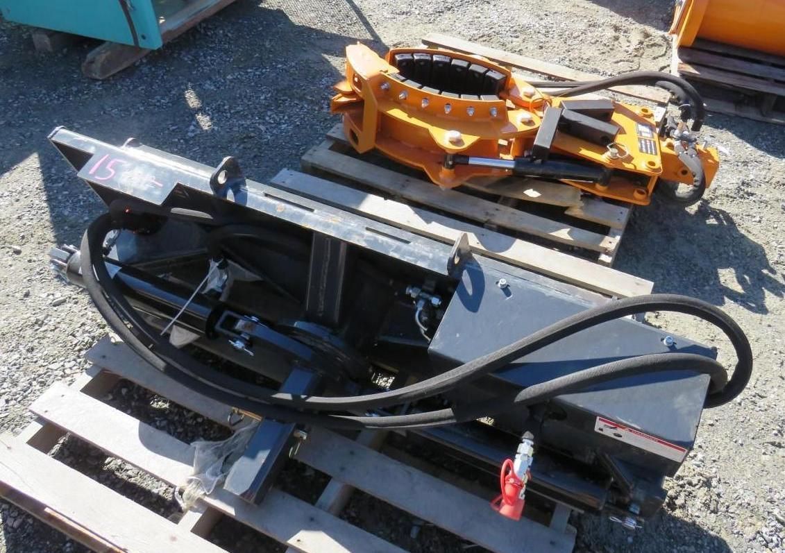 Hydraulic excavator attachments on wooden pallets.