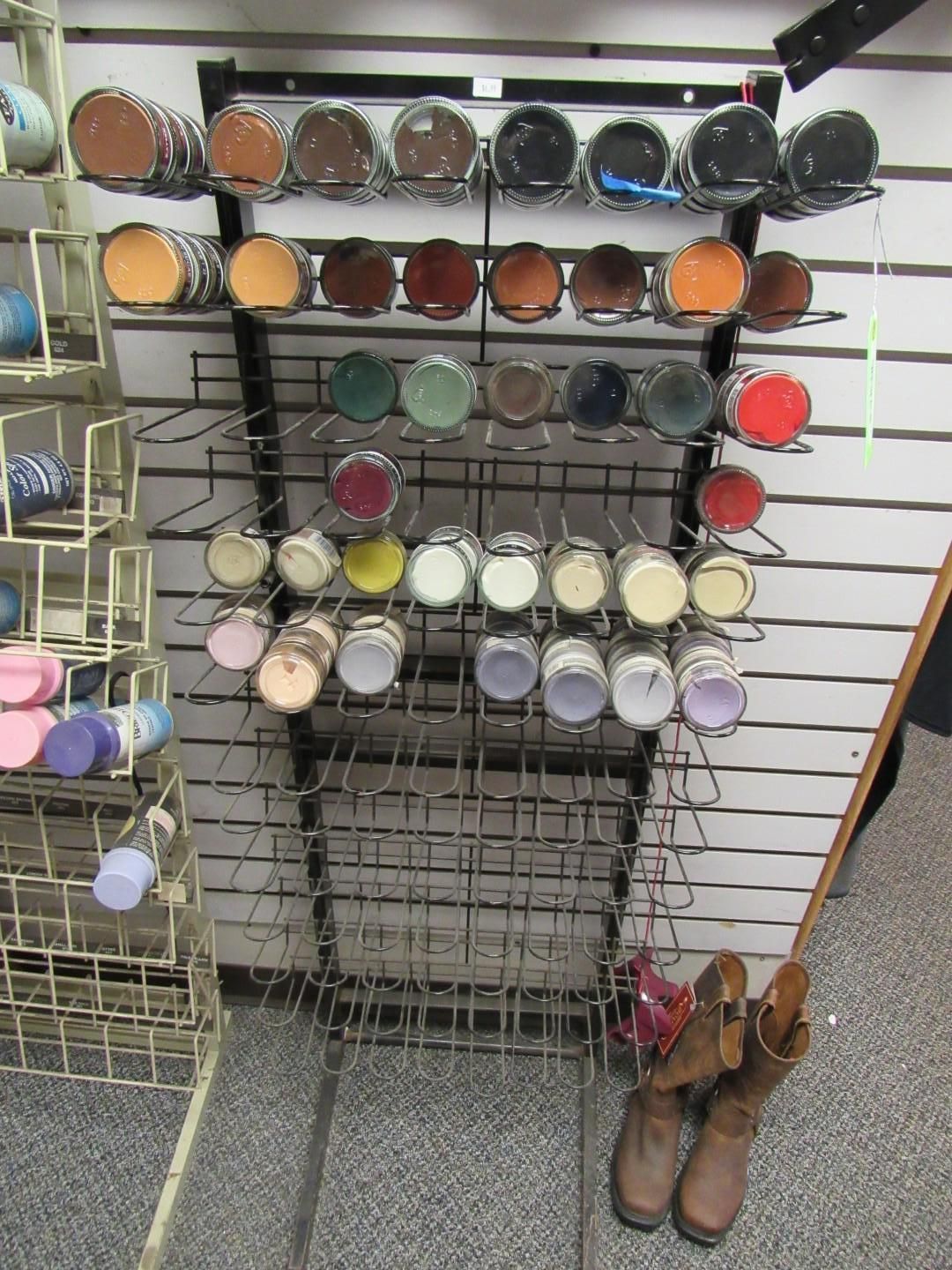 Wall display of various-colored shoe polishes in jars.