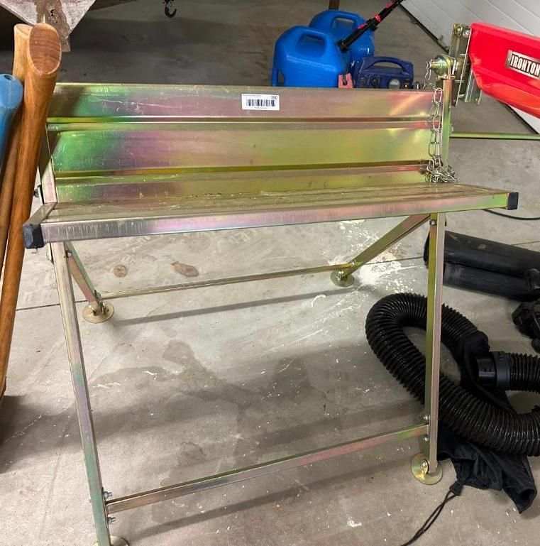 Metal sheet bender on a stand in a garage. Yellow and green tones.
