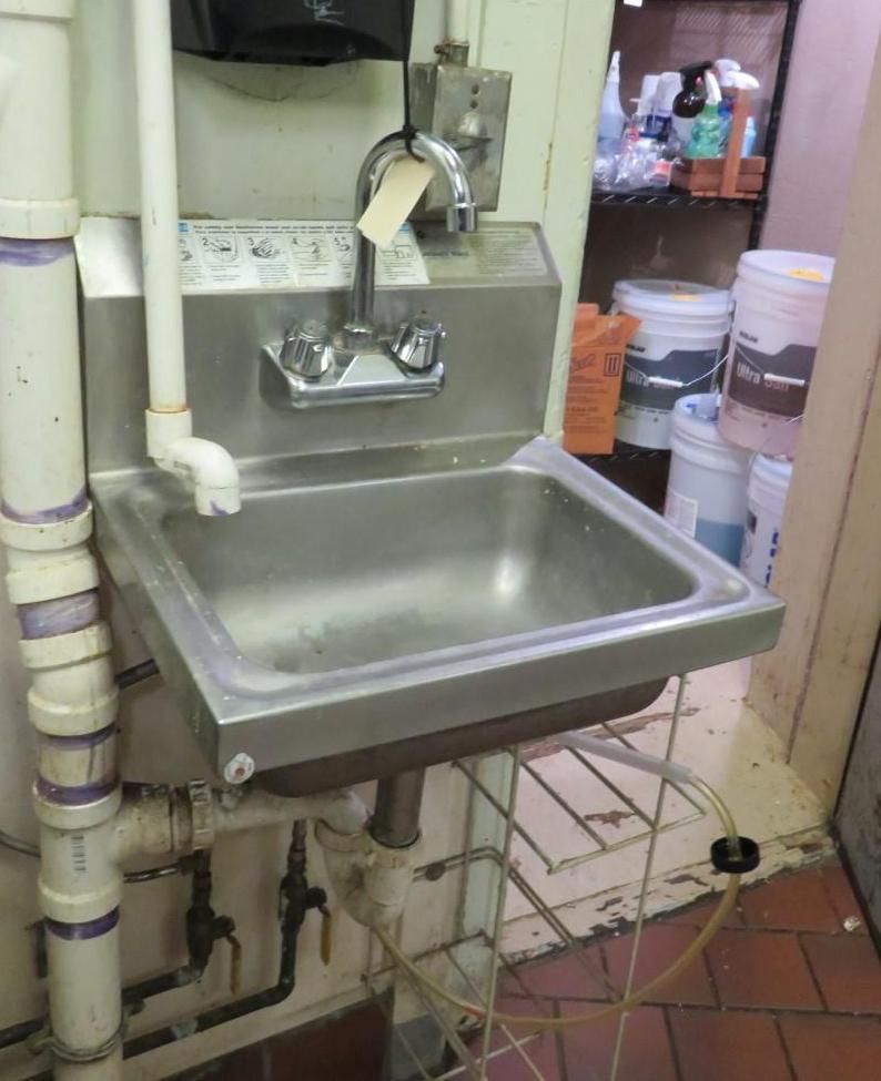 Stainless steel handwashing sink in a commercial kitchen.