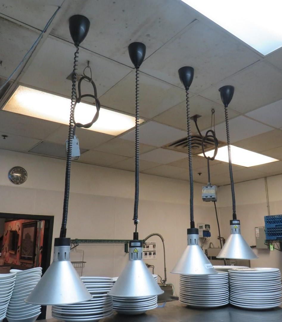 Four silver heat lamps hanging.
