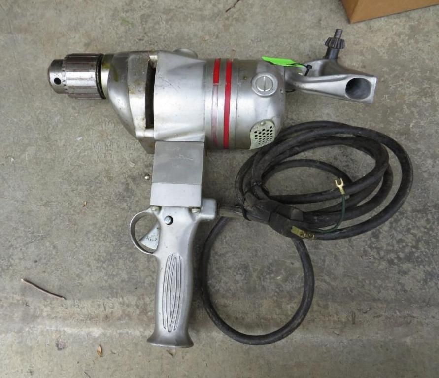 Silver, industrial-style electric drill with a pistol grip and side handle.