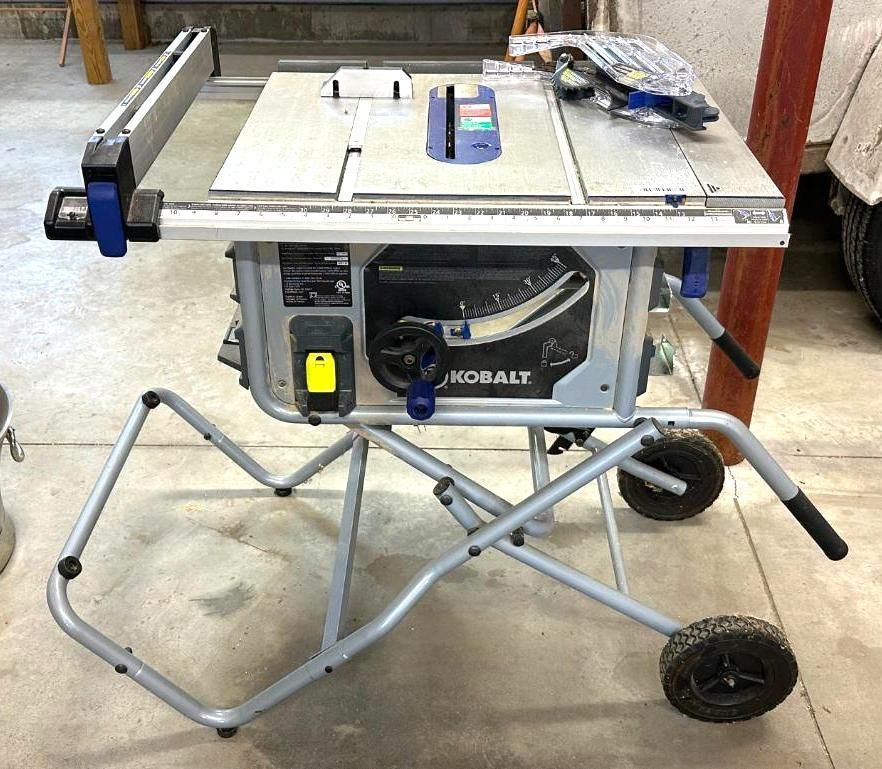 Kobalt portable table saw on a gray metal stand with wheels.