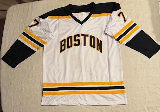 White Boston hockey jersey with black and yellow accents, number 77.