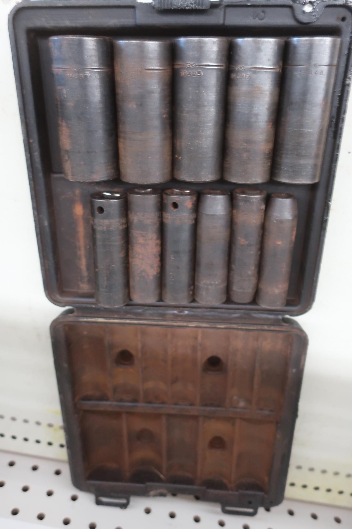 Open toolbox with a set of black impact sockets arranged inside.