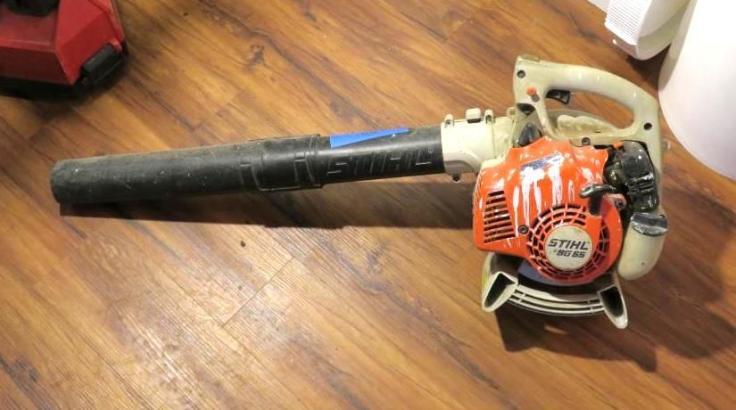 Stihl gas leaf blower on a wooden floor, orange and gray.