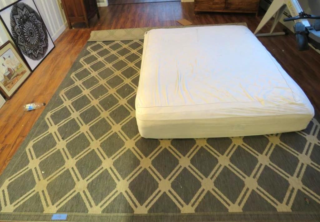 A patterned rug in a room with hardwood floors.