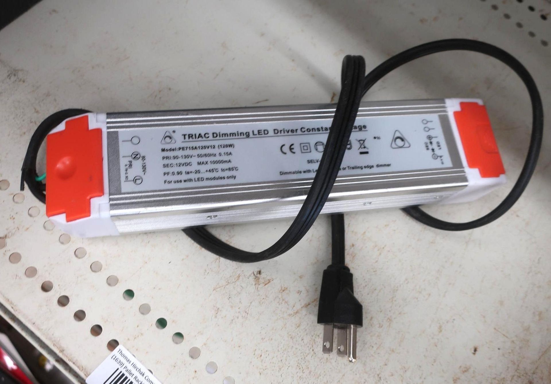 Silver LED driver with orange ends, black power cord, and plug.