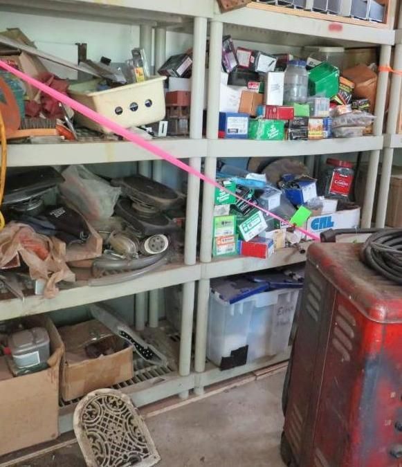 Shelving unit with boxes, tools, and supplies, secured with pink tape.
