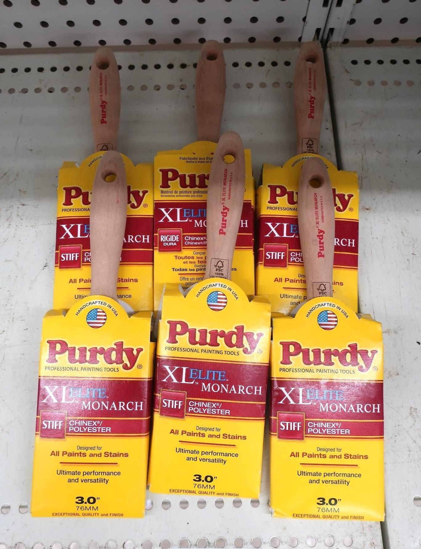 Six Purdy XL Elite Monarch paint brushes on a shelf. Yellow and red packaging with wooden handles.