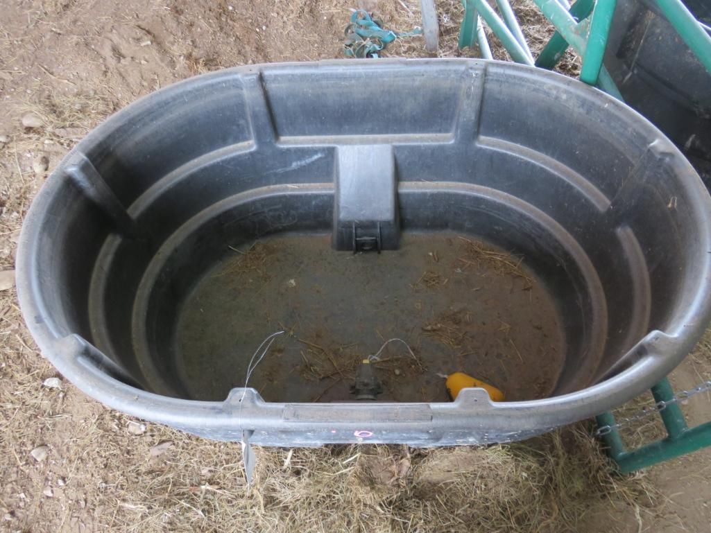 Black oval livestock water trough.