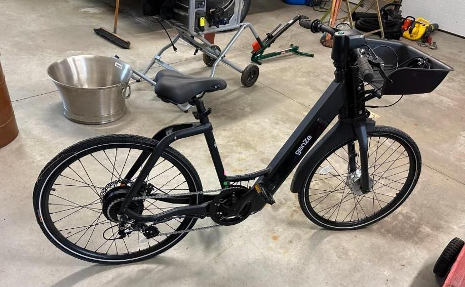 Black electric bike with basket, in a garage.