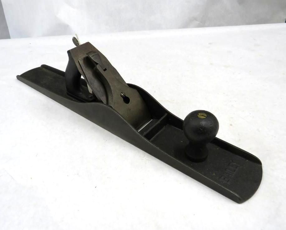 Black hand plane tool on a white surface, used for woodworking.