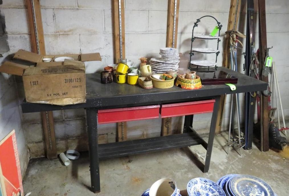 Workbench with red drawers, holding ceramics and boxes.