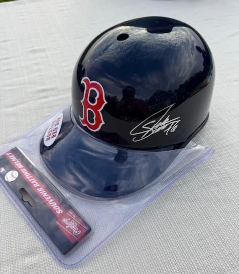 A Boston Red Sox baseball helmet with a signature, packaged with a Rawling's bat eraser.