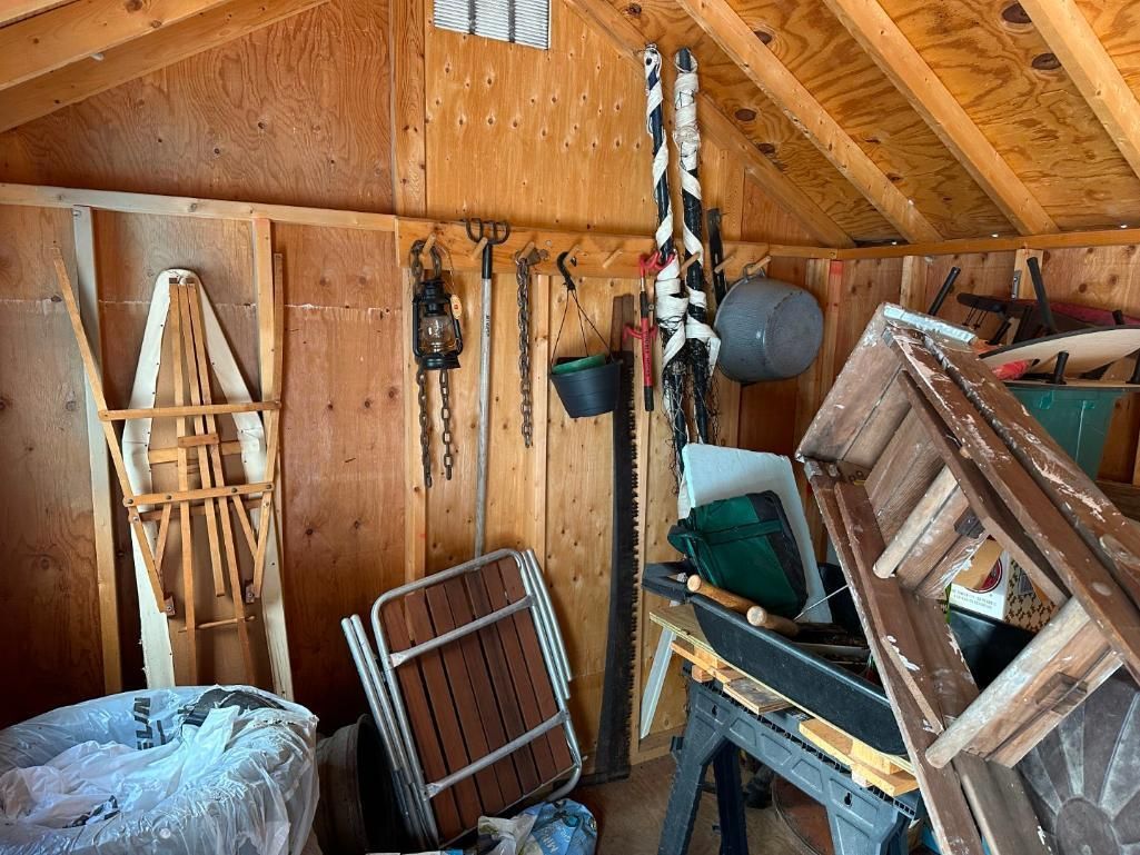 Wooden shed interior with tools and equipment.