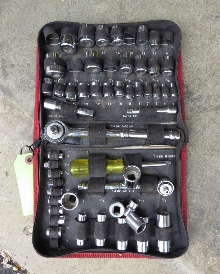 Red zippered tool kit open, containing various sockets, a ratchet, and extensions.