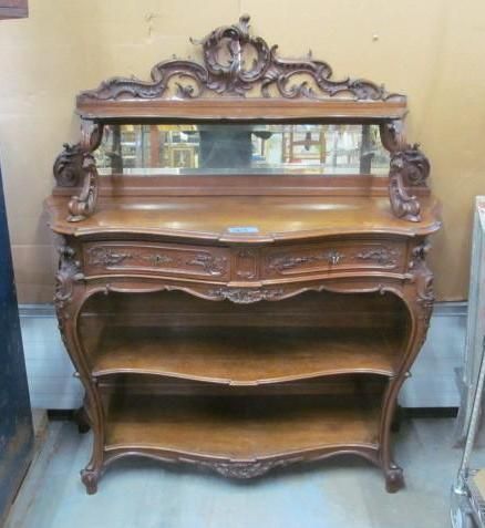Ornate wooden antique sideboard with mirror and open shelving.