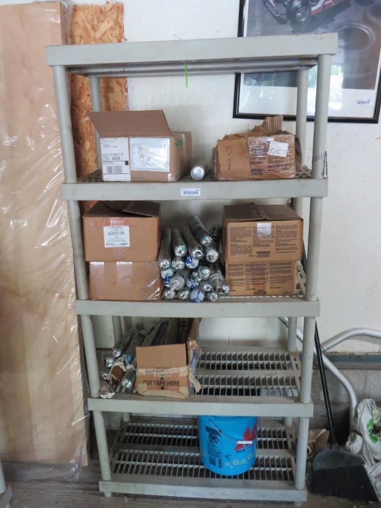 Plastic shelving unit holding boxes, metal rods, and a blue bucket.