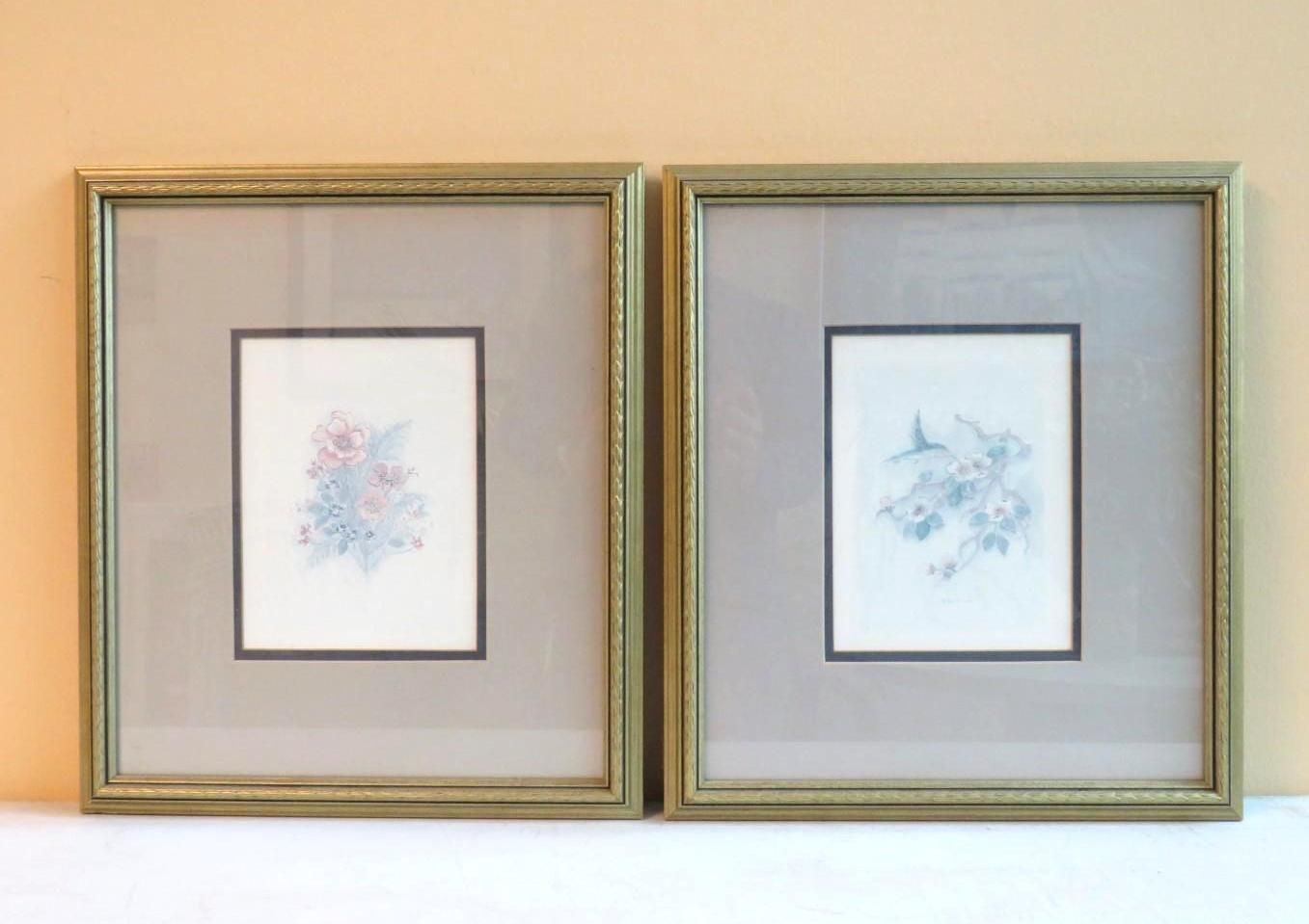 Two framed floral watercolor prints with gold borders.