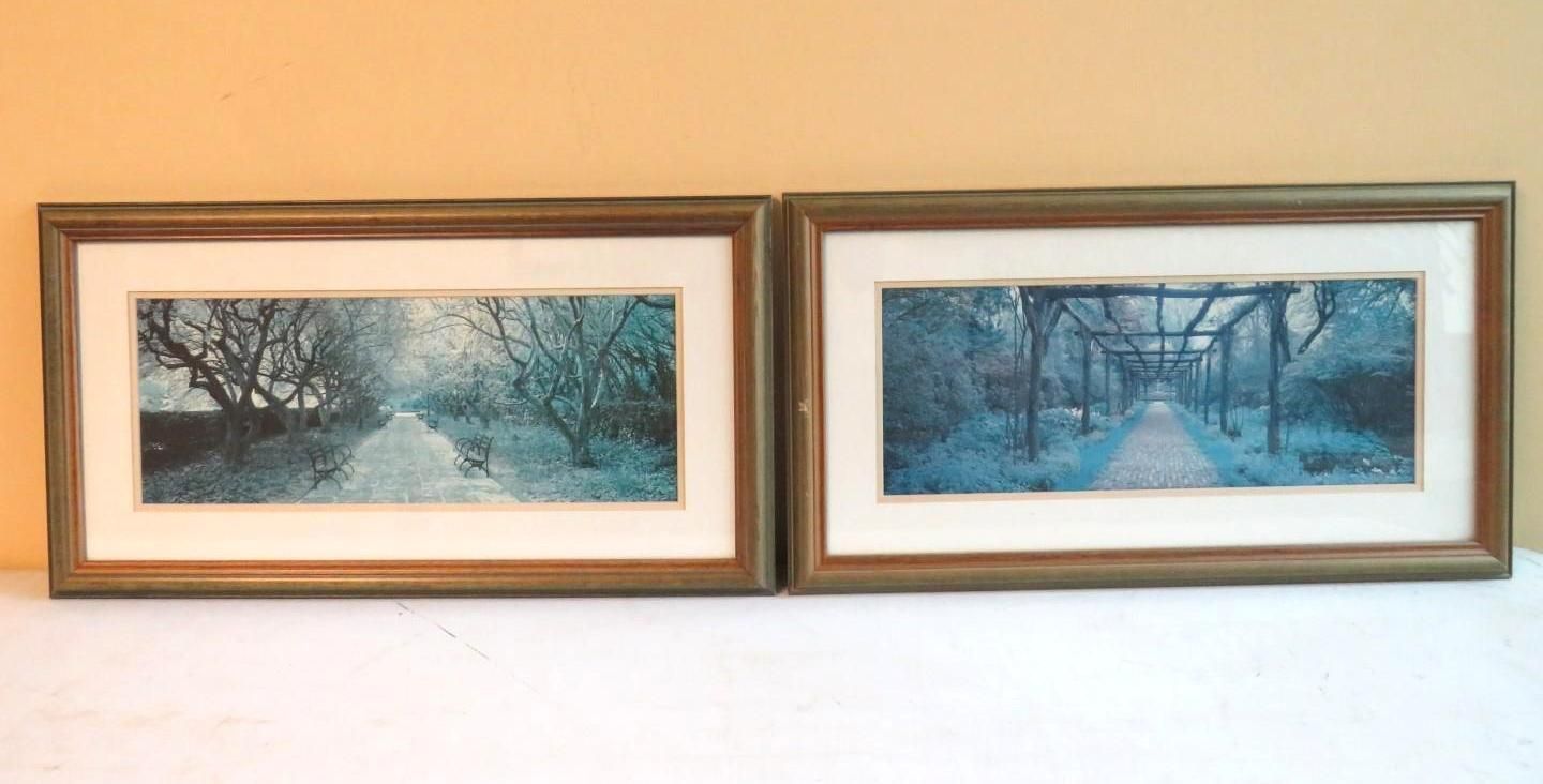 Two framed landscape art pieces with blue-toned trees and pathways.