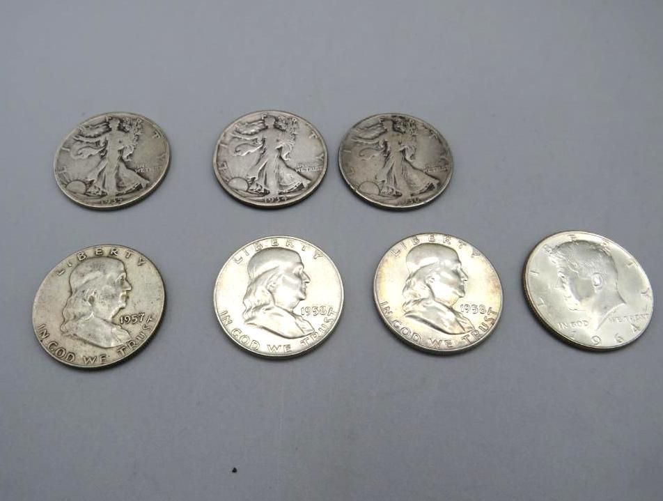 Seven silver coins: Four Franklin half dollars and three Walking Liberty half dollars.
