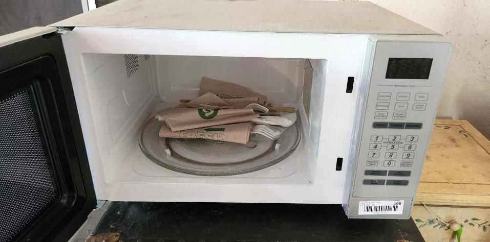 Open microwave containing a glass plate.