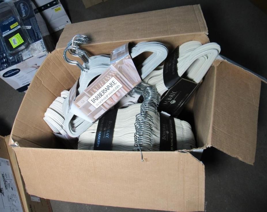 Cardboard box filled with wrapped garment hangers; beige and silver colors visible.