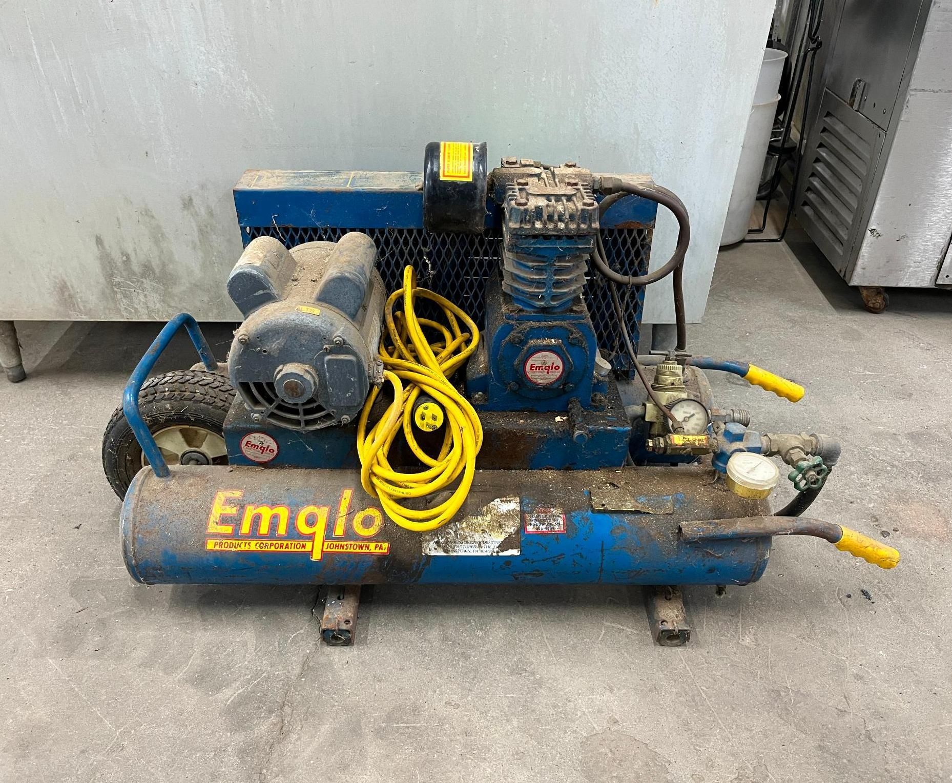 Blue Emglo air compressor with yellow cord and handles.