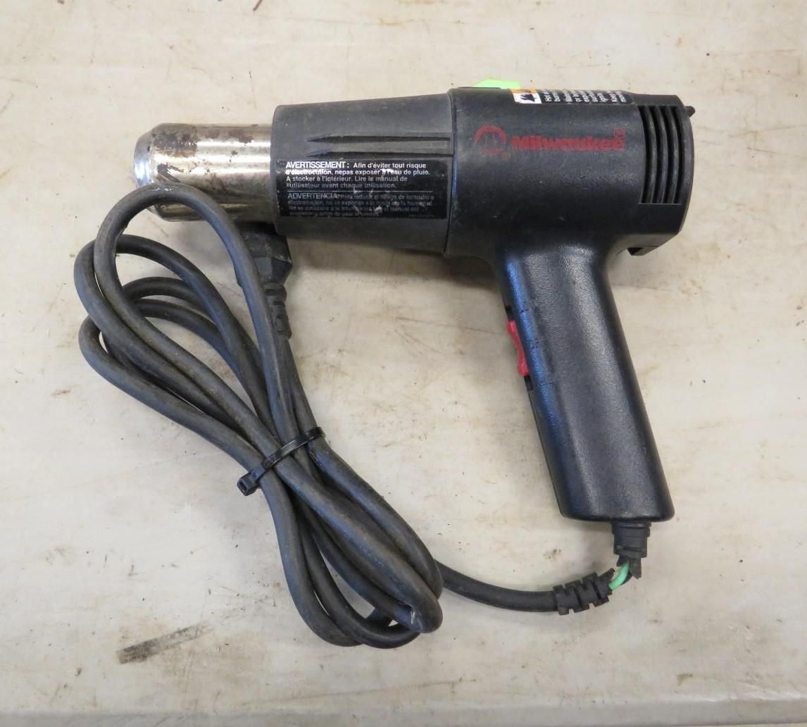 Black heat gun with power cord on a gray surface.