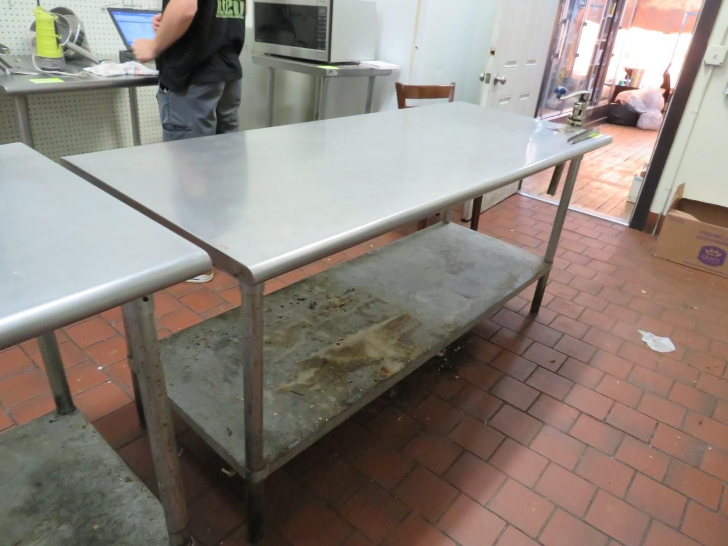 Two stainless steel tables in a commercial kitchen.