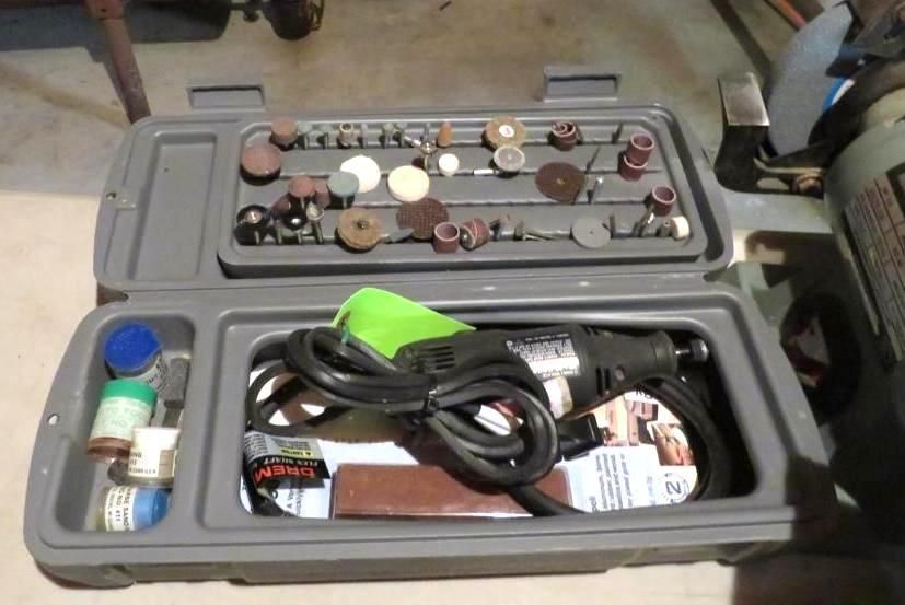 Gray tool kit open, containing rotary tool, accessories, and grinding bits.