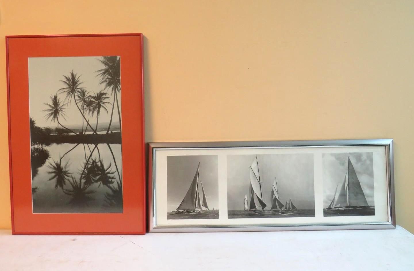 Two framed black and white photos: palms reflected in water, sailboats at sea. Orange and silver frames.