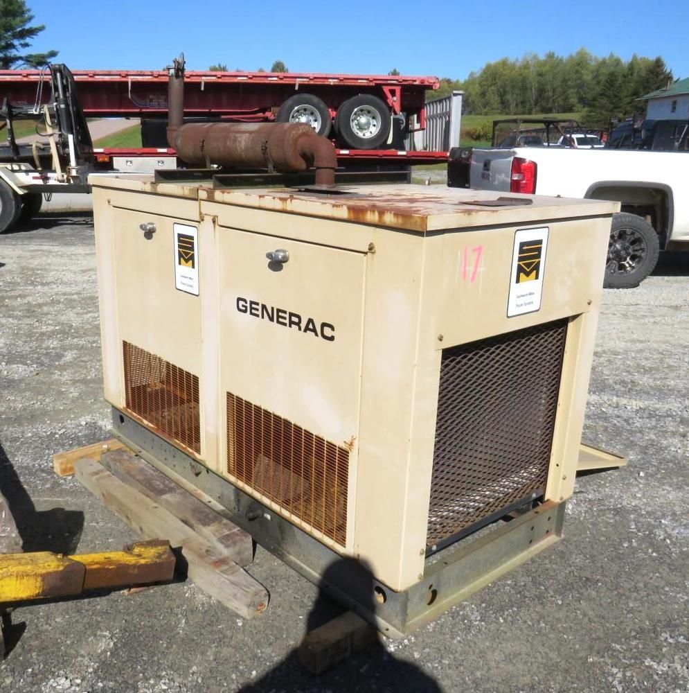 Beige Generac generator on wooden pallet, outdoors. Rusty exhaust pipe, metal grates, and markings.