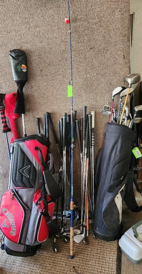 Golf clubs and fishing rod leaning against a wall, next to golf bags.