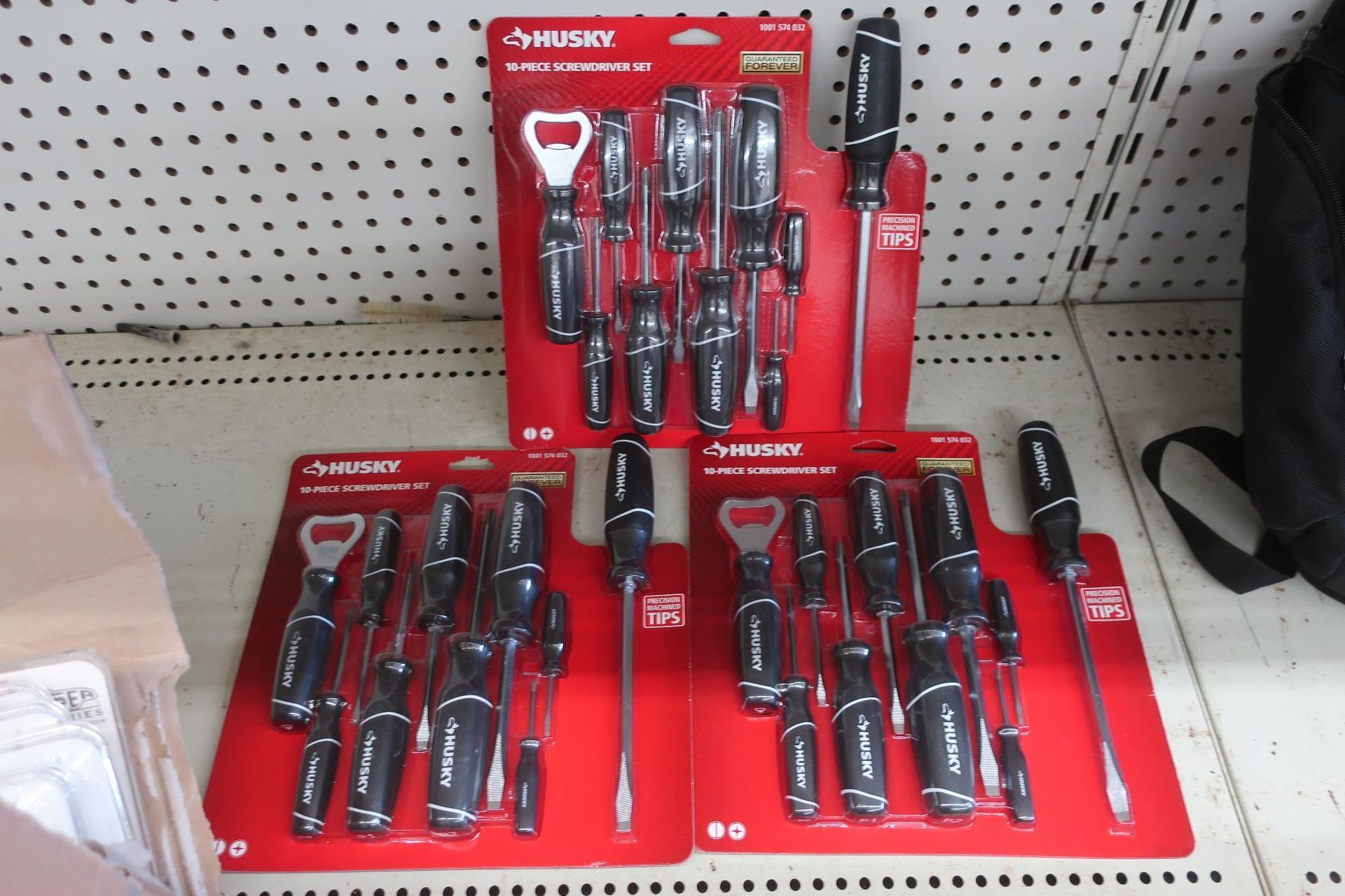 Three packages of Husky screwdriver sets displayed on a store shelf, red packaging with black and silver tools.