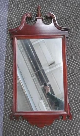 Mahogany-framed mirror, ornate top and bottom detailing.