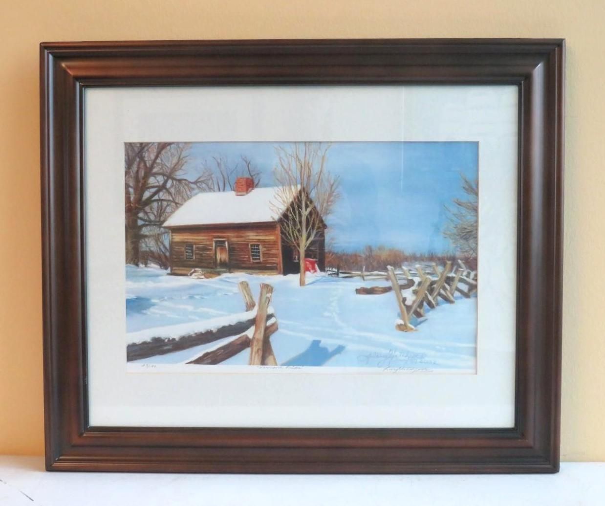 Framed winter landscape: snow-covered log cabin with a fence, set against a blue sky.