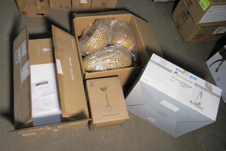 Open cardboard boxes containing various lamps and lighting fixtures.