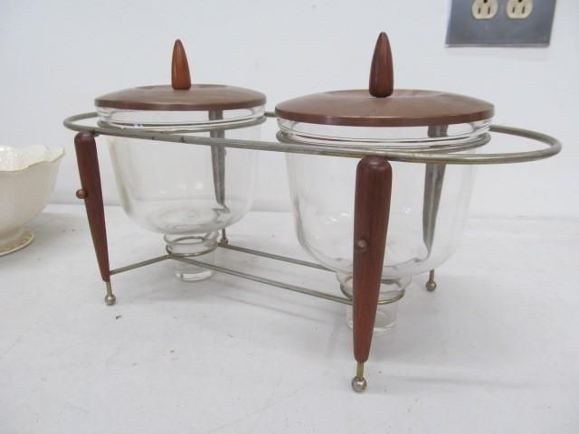 Glass and wood condiment set with two jars and lids in a metal frame.