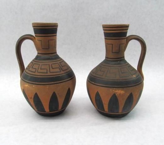 Two terracotta-colored jugs with black Greek key and petal designs.