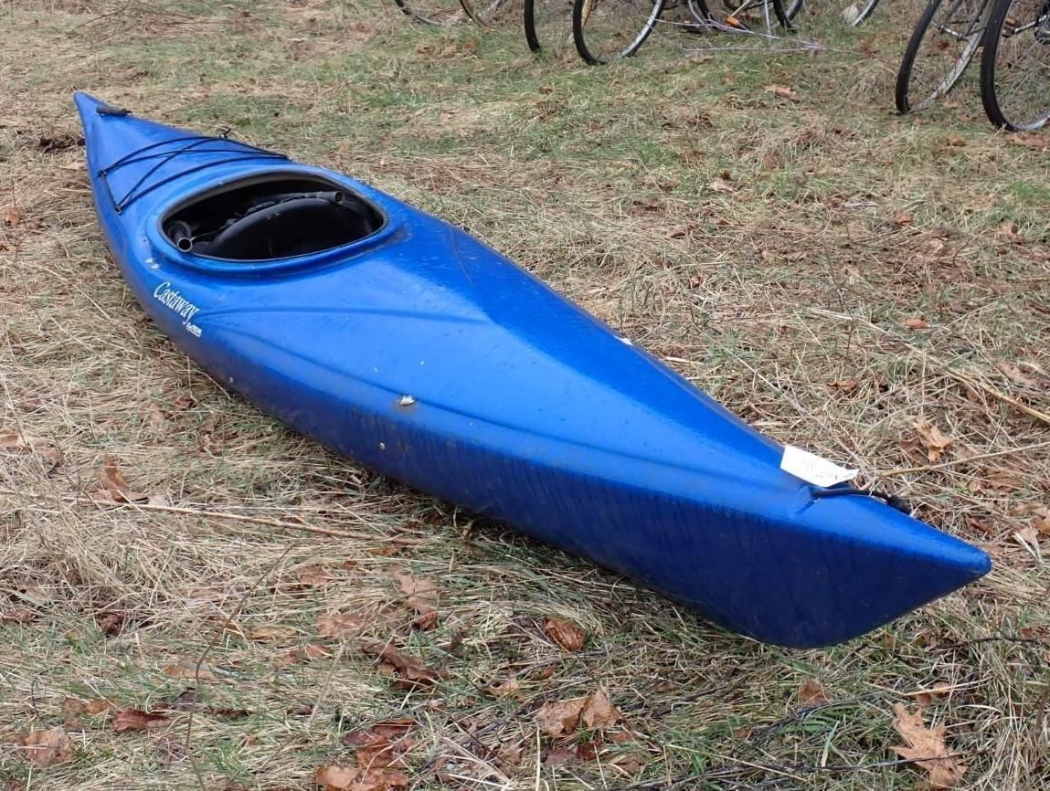 A bright blue kayak resting on the grass.
